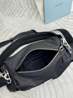 Prada dark nylon mini bag with zip front pocket and shoulder strap, angled top view.
