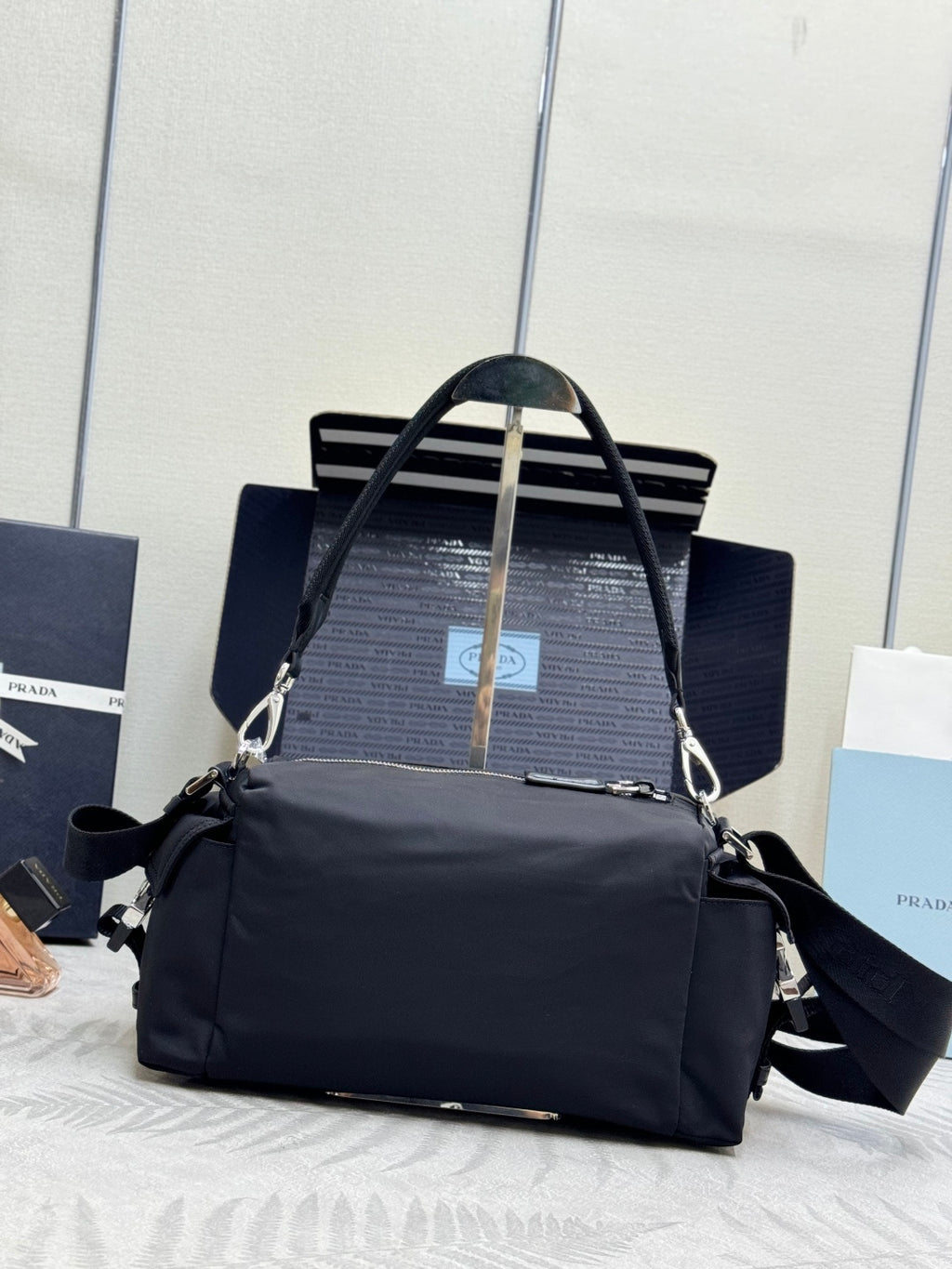 Prada dark nylon handbag with top handles and shoulder strap, front view with logo patch.