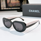 Sunglasses with black frames and dark lenses, rounded cat-eye shape with Chanel logo