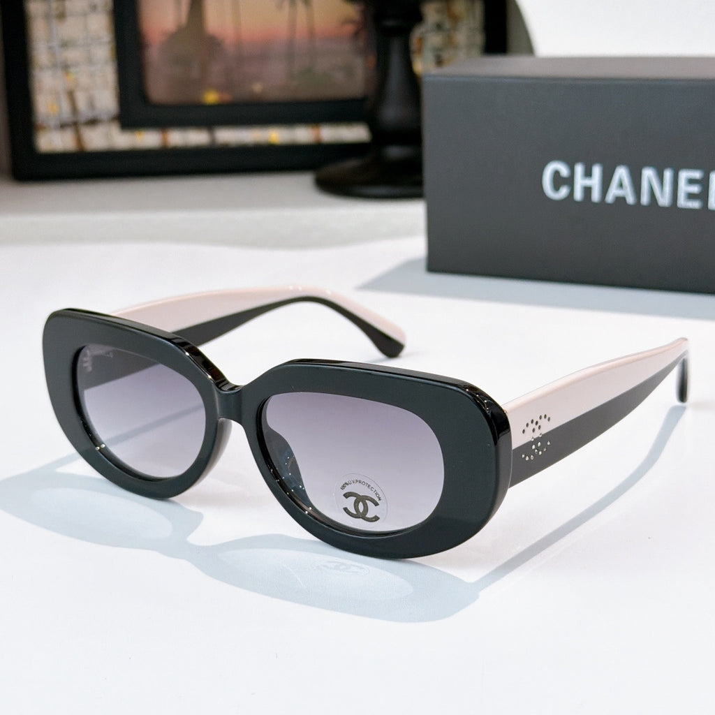 Sunglasses with dark frames and purple-tinted lenses, cat-eye style with Chanel logo