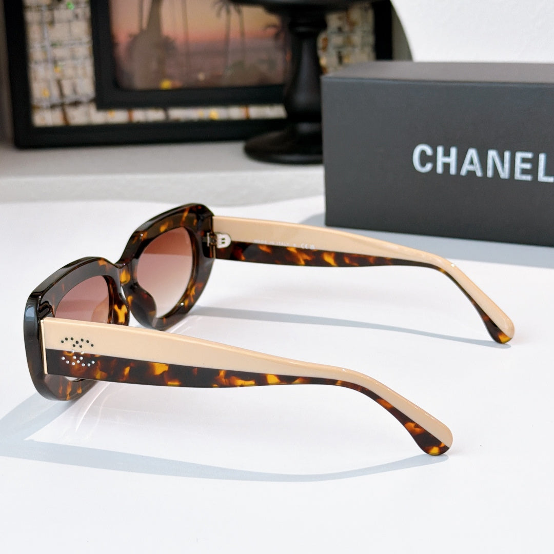 Sunglasses side view with tortoiseshell frames, light beige arms, and perforated temple detail