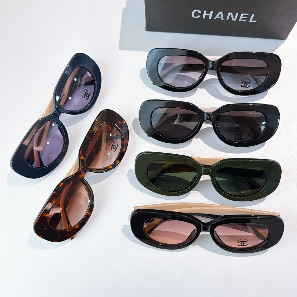 Assorted sunglasses on display with blue, tortoiseshell, green, and black frames