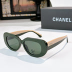 Sunglasses with dark green frames and green-tinted lenses, cat-eye shape with Chanel logo
