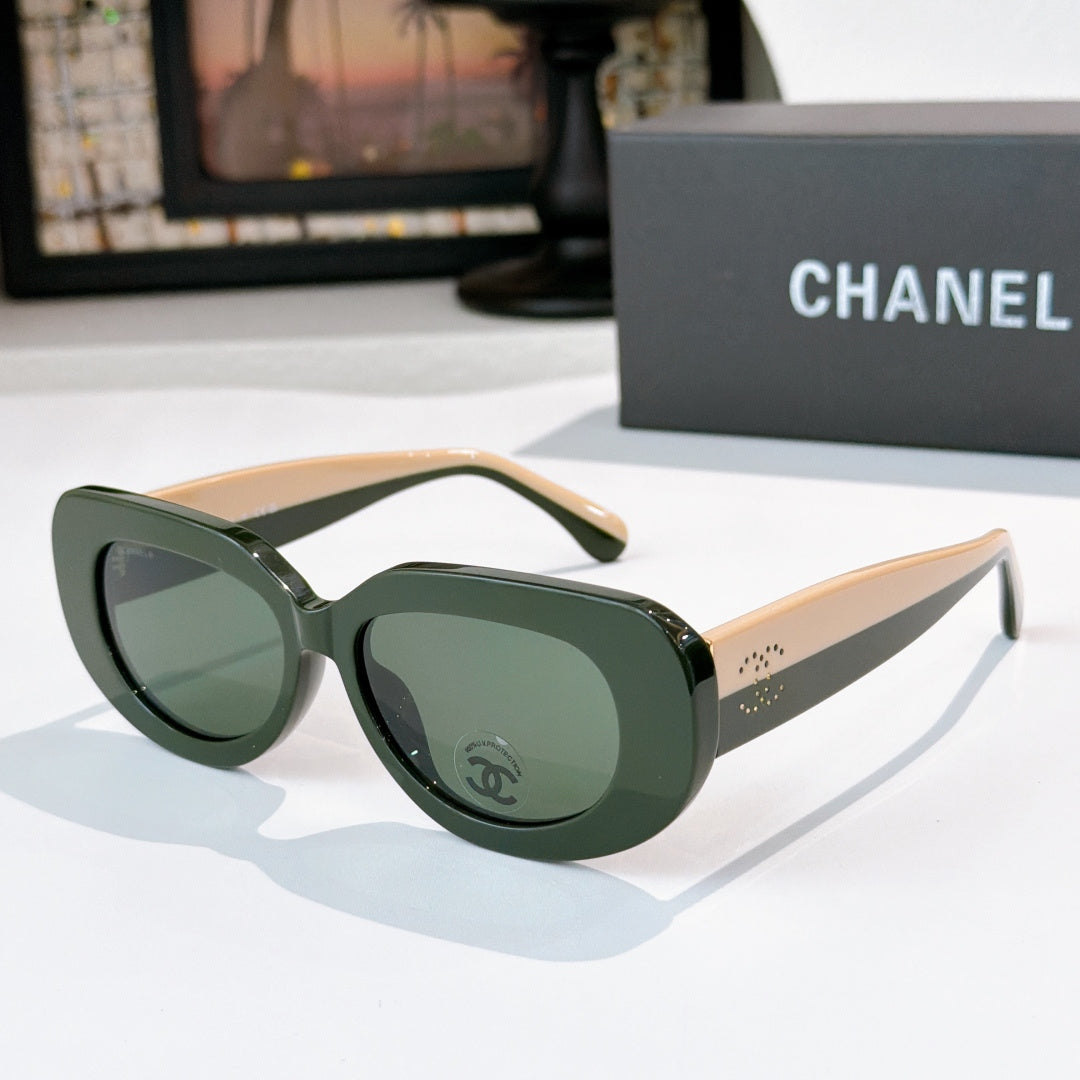 Sunglasses with dark green frames and green-tinted lenses, cat-eye shape with Chanel logo