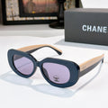 Sunglasses with dark blue frames and purple-tinted lenses, wide cat-eye shape