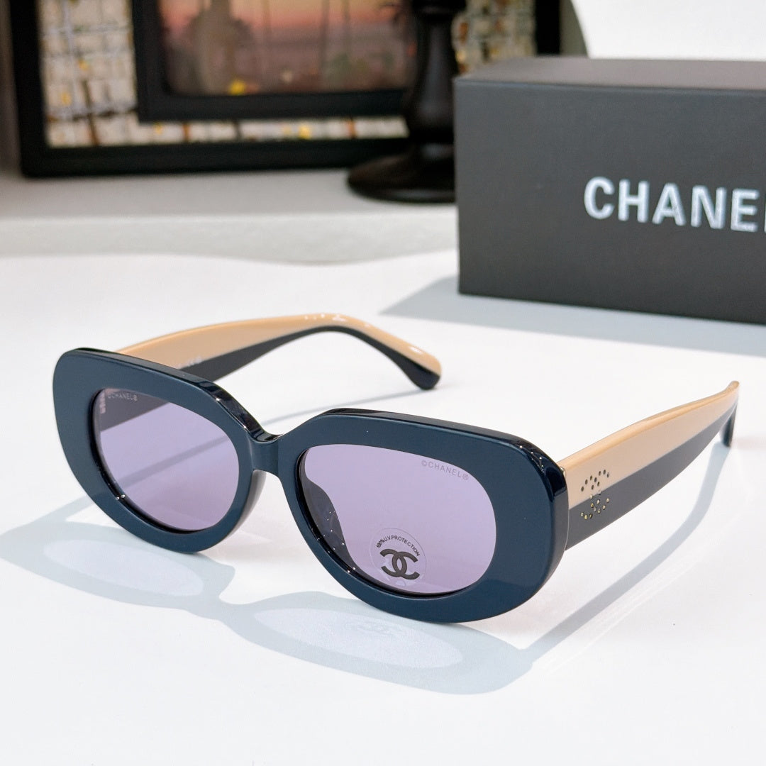 Sunglasses with dark blue frames and purple-tinted lenses, wide cat-eye shape