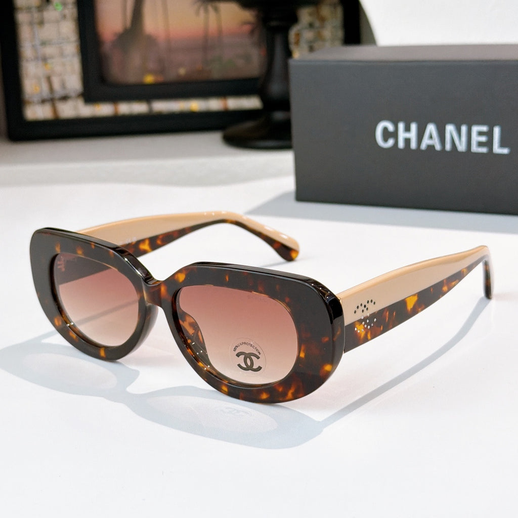 Sunglasses with tortoiseshell frames and amber-pink tinted lenses, cat-eye shape with Chanel logo