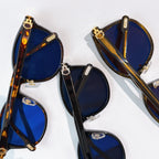 Cartier sunglasses close-up with blue lenses and mixed black/tortoiseshell frames