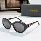 Black round cat-eye sunglasses with dark tinted lenses and gold hinge detail