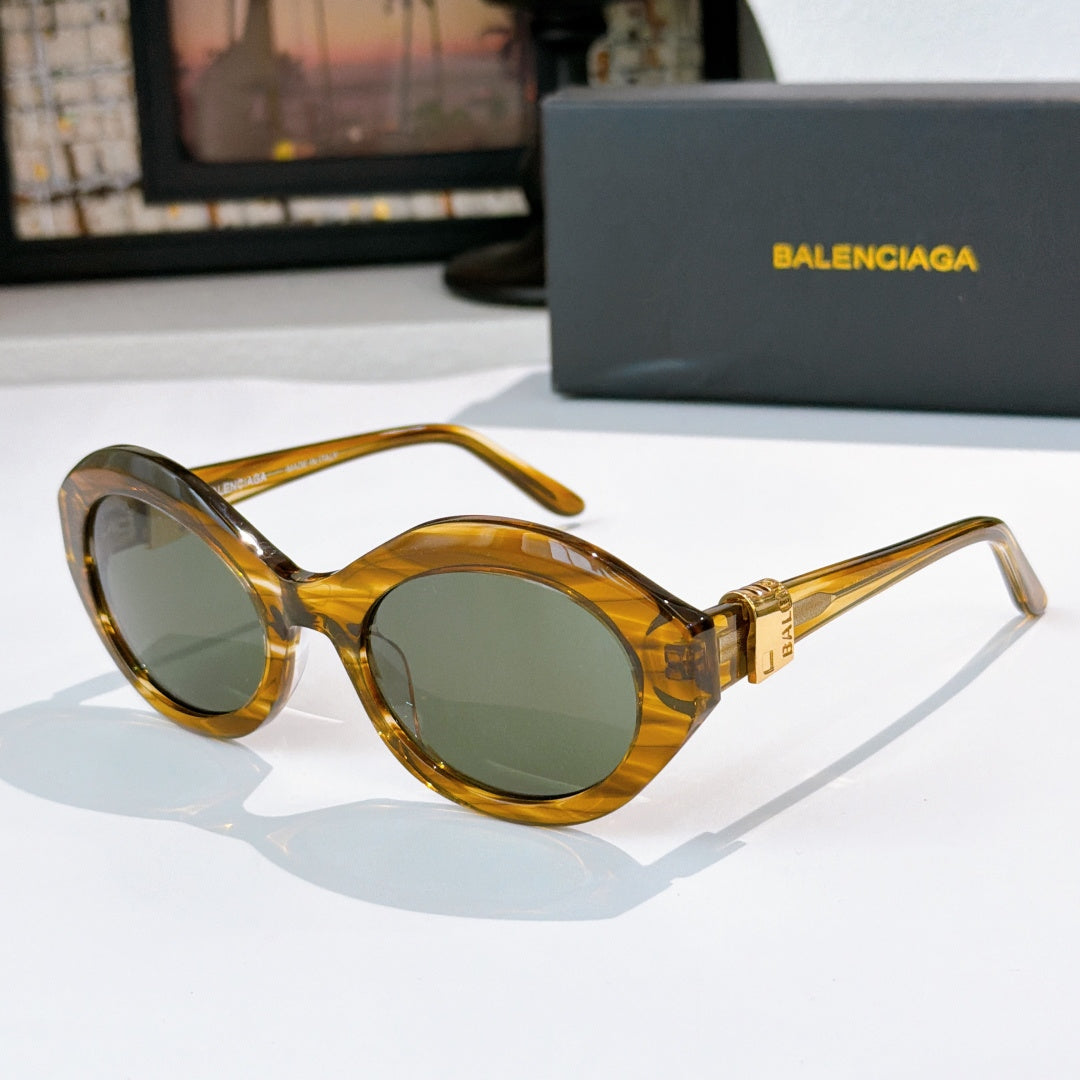Honey amber round cat-eye sunglasses with green tinted lenses and gold hinge detail