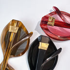 Assorted sunglasses in amber, red, and black with gold logo hinges and tinted lenses