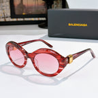 Red round cat-eye sunglasses with pink tinted lenses and gold hinge detail