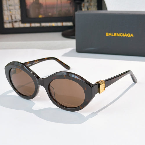 Black tortoiseshell round cat-eye sunglasses with brown tinted lenses and gold hinge