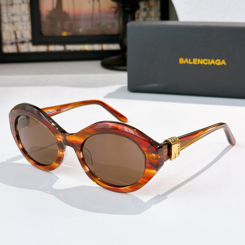 Orange tortoiseshell round cat-eye sunglasses with brown tinted lenses and gold hinge