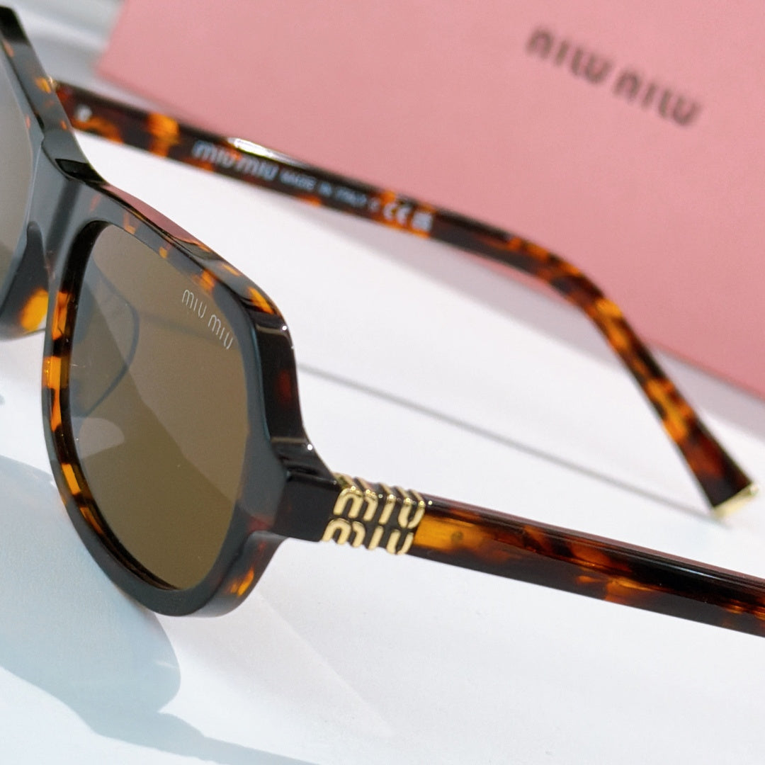 Tortoiseshell sunglasses close-up with dark tinted lens and gold logo on temple