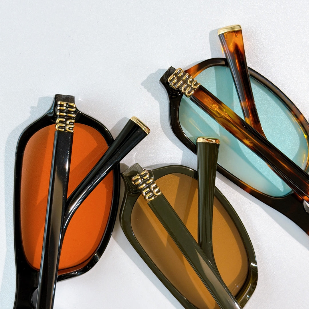 Sunglasses pair close-up: one black frame with orange lens, one tortoiseshell with blue lens