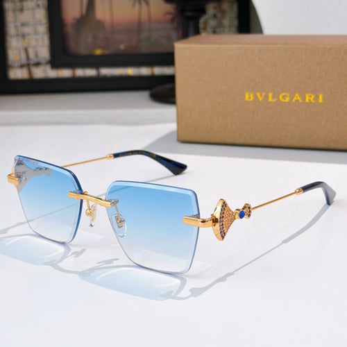 Bvlgari sunglasses with blue gradient lenses, gold frame, jeweled bridge detail.