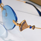 Bvlgari sunglasses close-up: gold bow detail with blue accents and blue lens.