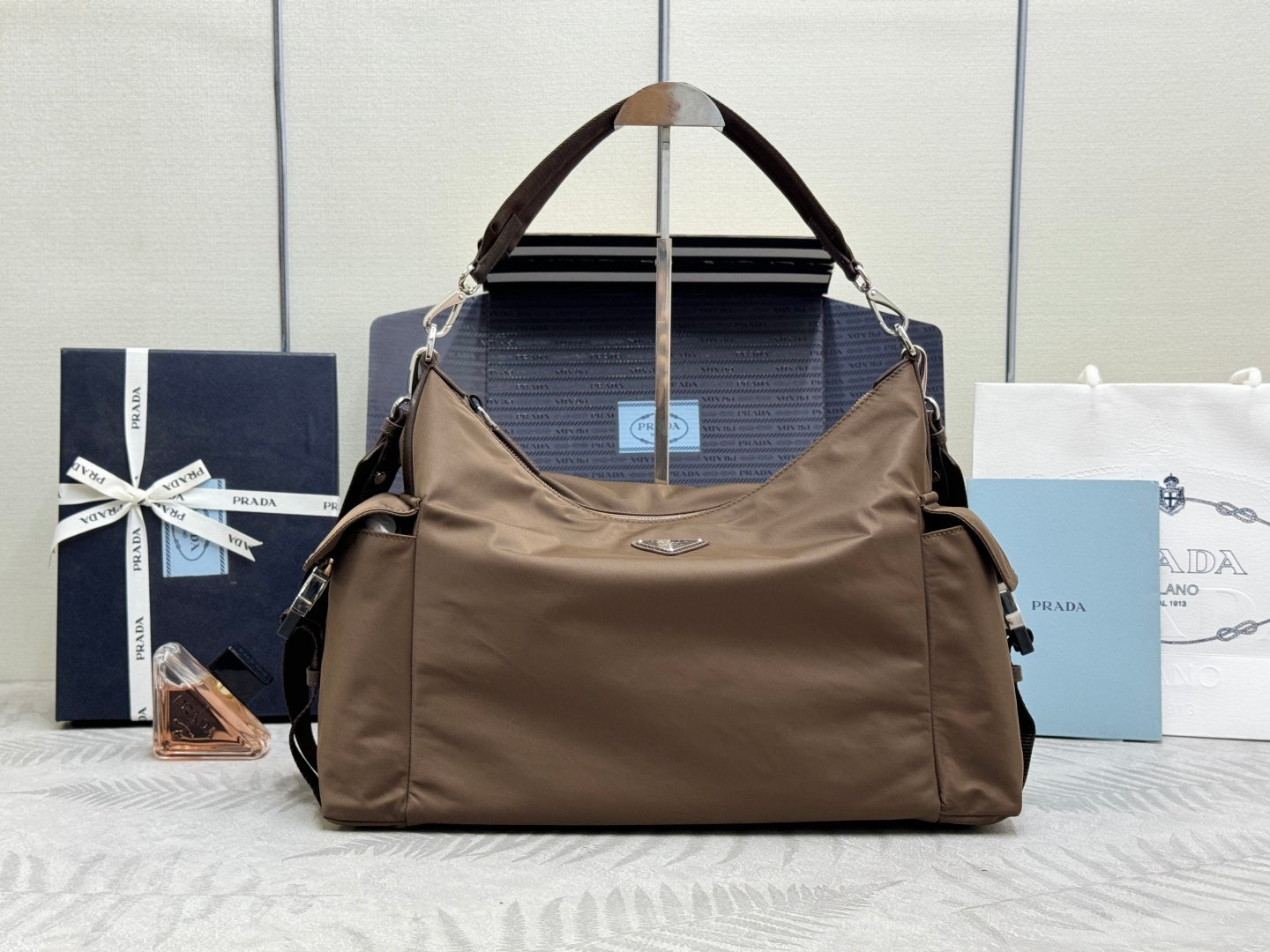Brown nylon hobo bag with top handle, double straps, and metal rings
