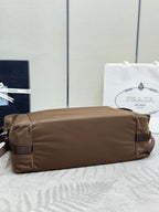 Taupe nylon hobo bag lying flat with side pocket and top zipper