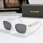White marbled cat-eye eyeglasses with dark lenses and gold logo detail