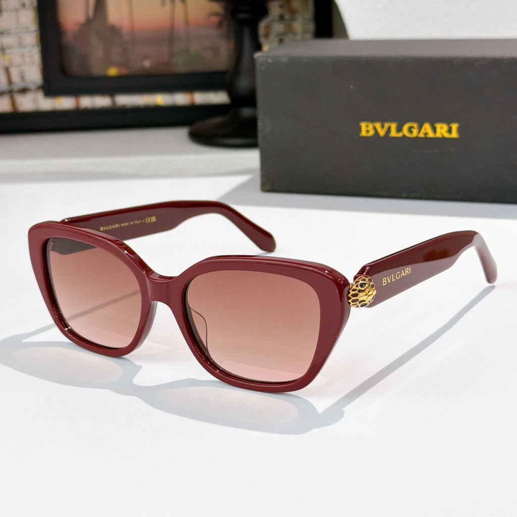 Red square eyeglasses with pink-tinted lenses and gold logo detail