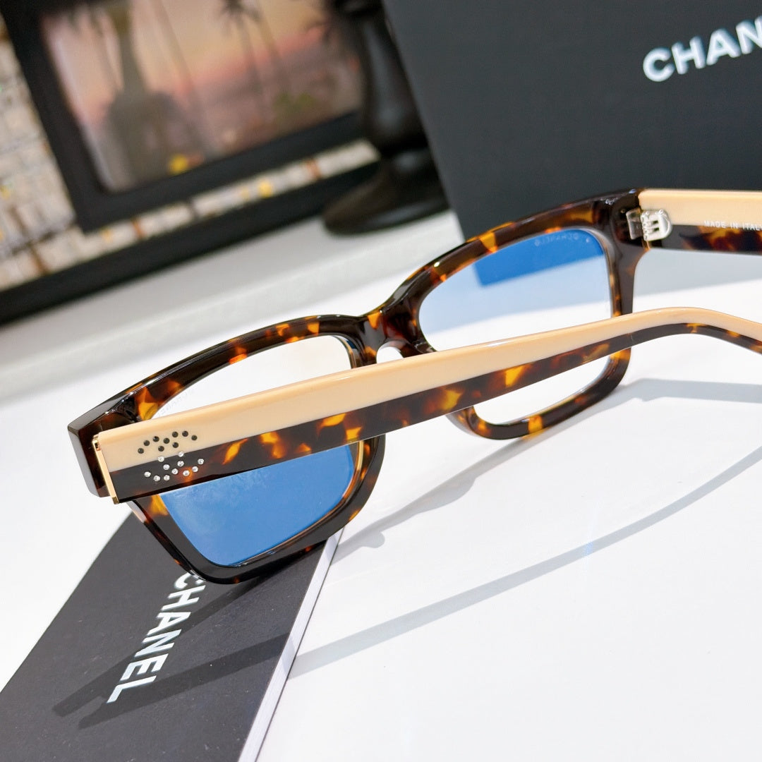 Chanel eyeglasses close-up with tortoiseshell frames and blue-tinted lenses, metal bridge