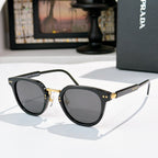 Prada glasses, black frames with dark gray lenses and gold hinge details