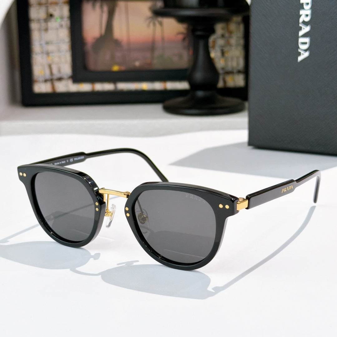 Prada glasses, black frames with dark gray lenses and gold hinge details