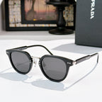 Prada glasses, dark frames with smoke lenses and gold bridge hardware