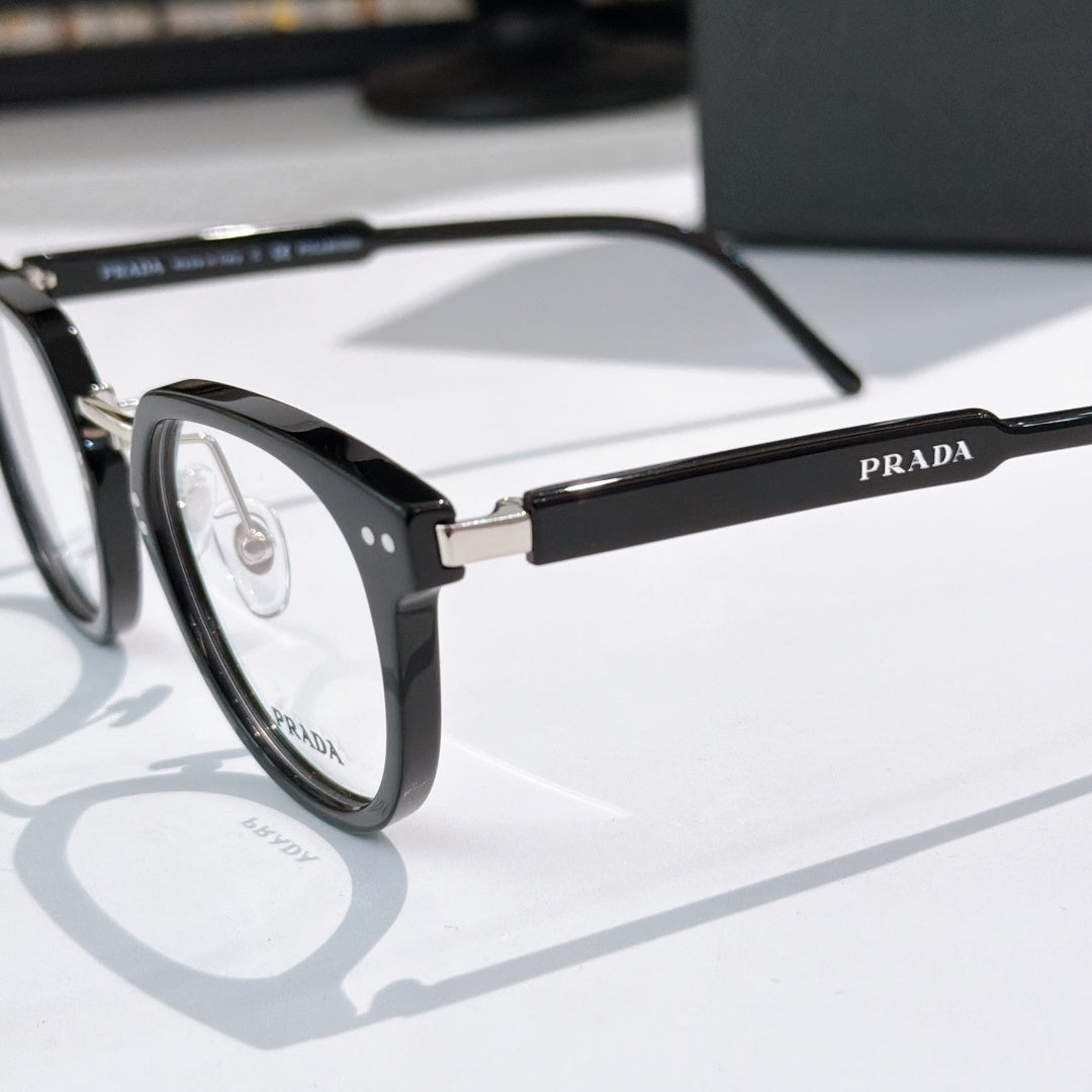 Prada glasses, close-up black frame with silver temples and gold logo bar
