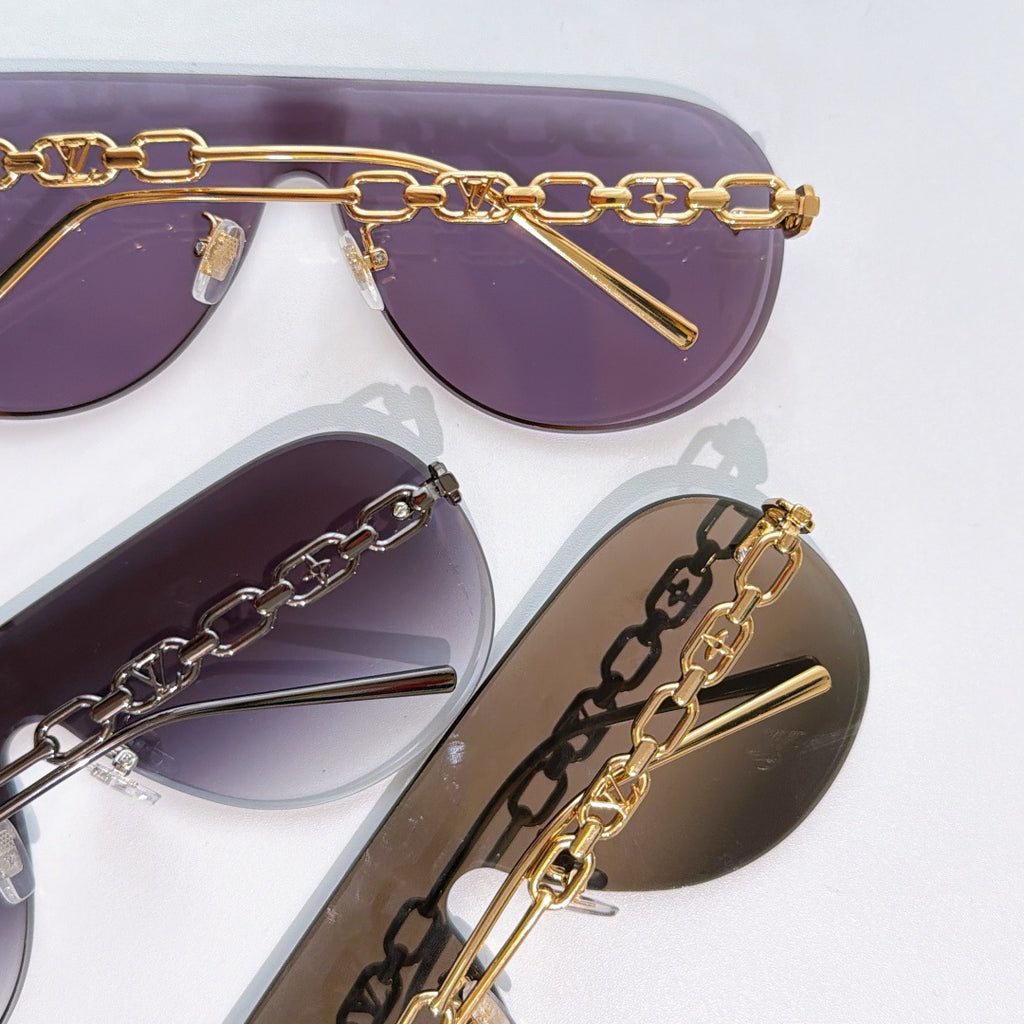 Louis Vuitton sunglasses close-up with purple and brown lenses, gold chain frame