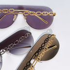 Louis Vuitton sunglasses close-up with purple and brown lenses, gold chain frame