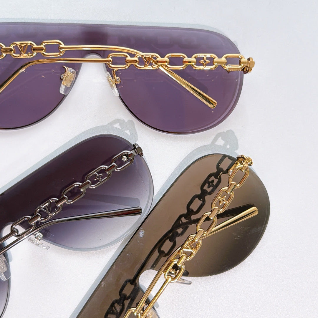 Louis Vuitton sunglasses close-up with purple and brown lenses, gold chain frame