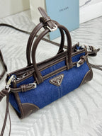 Blue denim Prada handbag with brown leather trim and adjustable shoulder strap