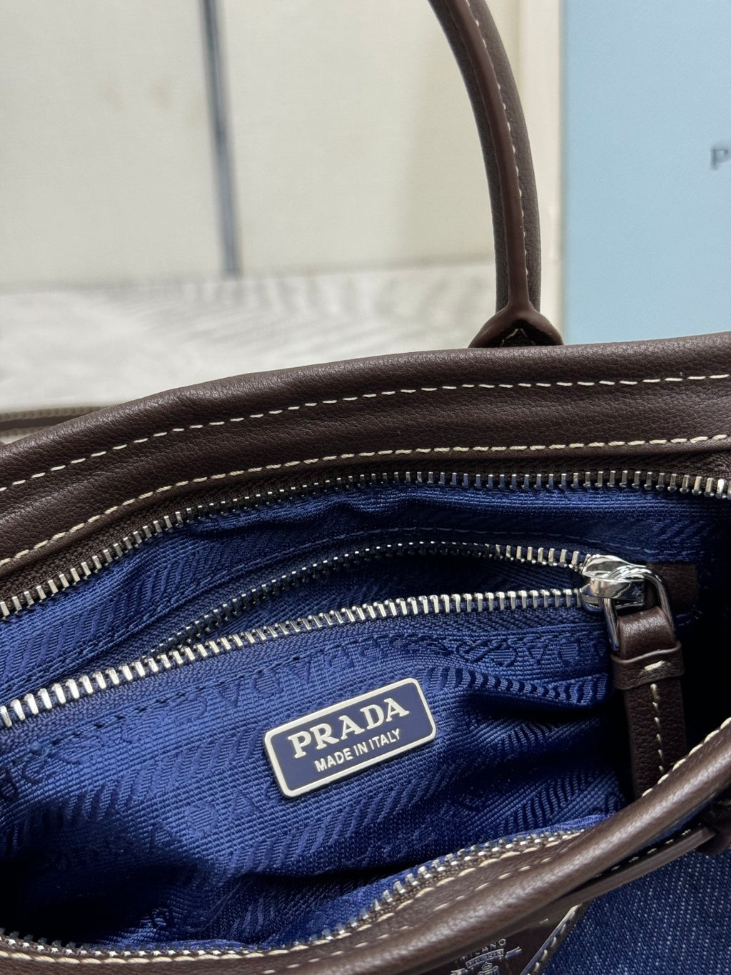 Interior of Prada handbag with blue lining, zip pocket, and logo label
