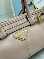 Prada light pink leather bag close-up of logo plate, gold trim, stitched panel