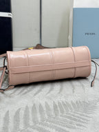 Prada light pink mini cylindrical bag with top zipper, gold hardware, crossbody strap
