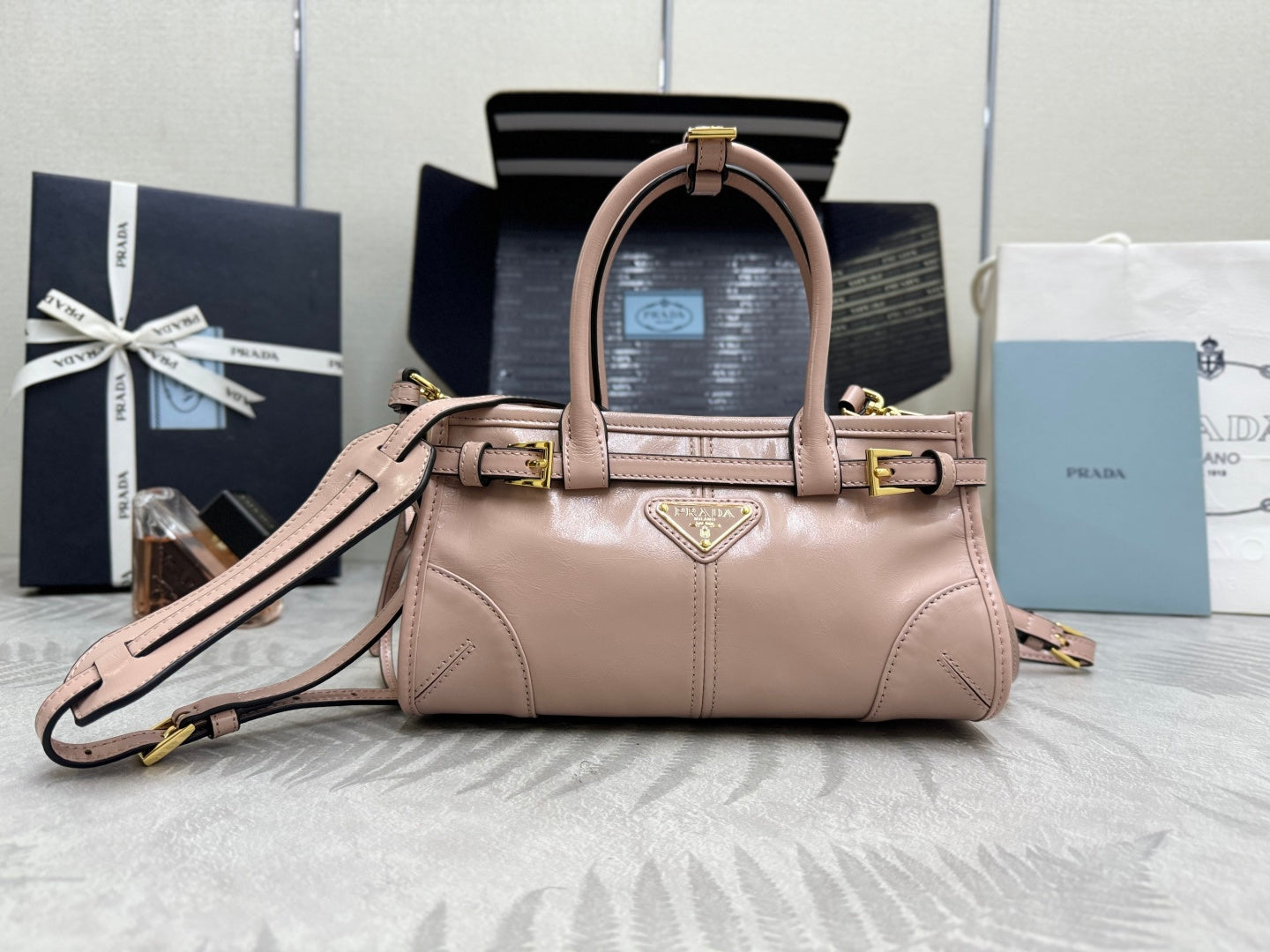 Prada mini tote bag in light pink with handles, gold hardware, detachable strap