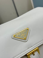 White Prada handbag logo patch with gold lettering on leather flap