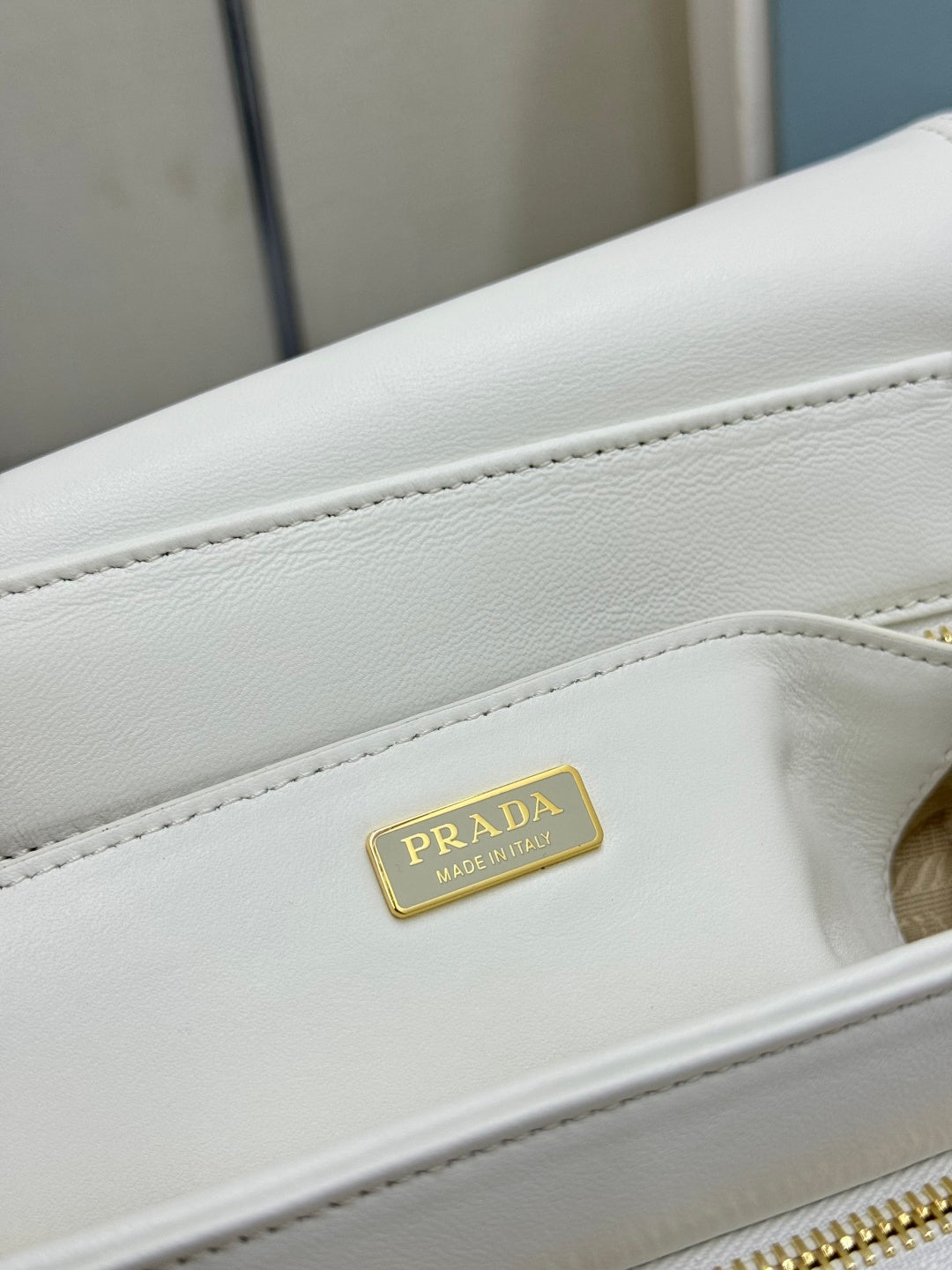 White Prada handbag leather edge with small gold Prada logo plaque