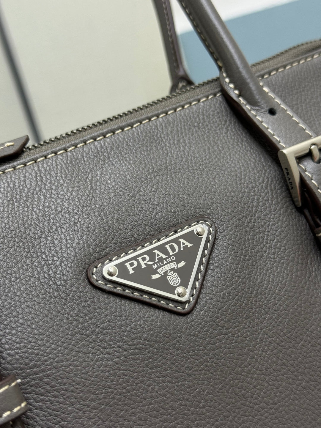 Prada gray leather handbag triangle logo metal plate on textured leather.