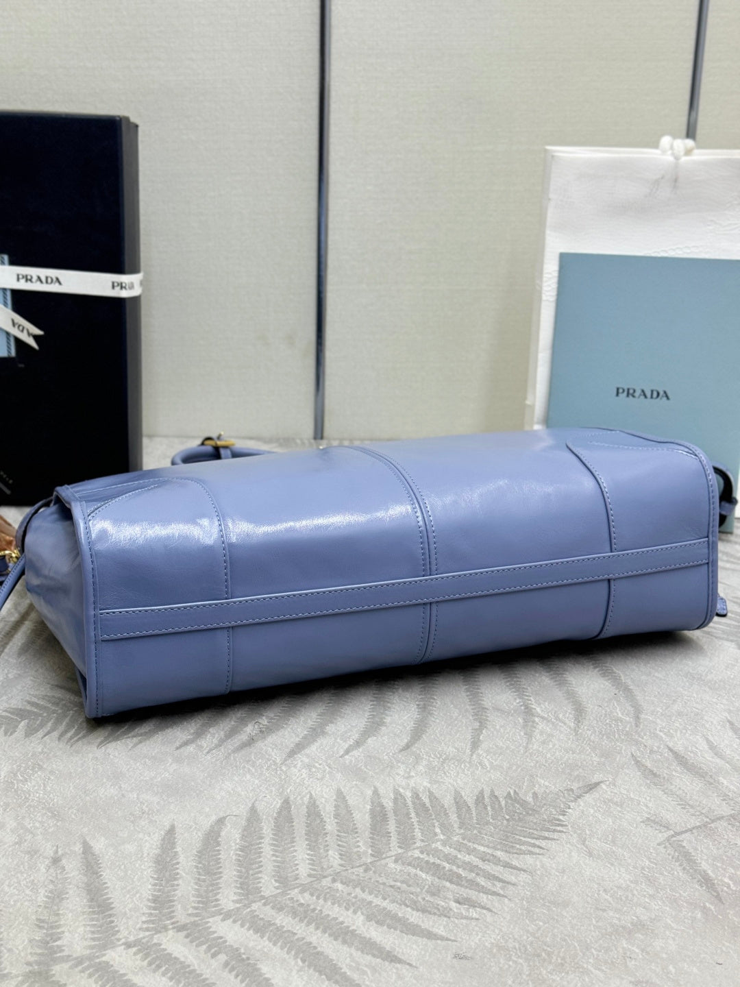 Light blue Prada leather duffel bag with top handle and front strap detail