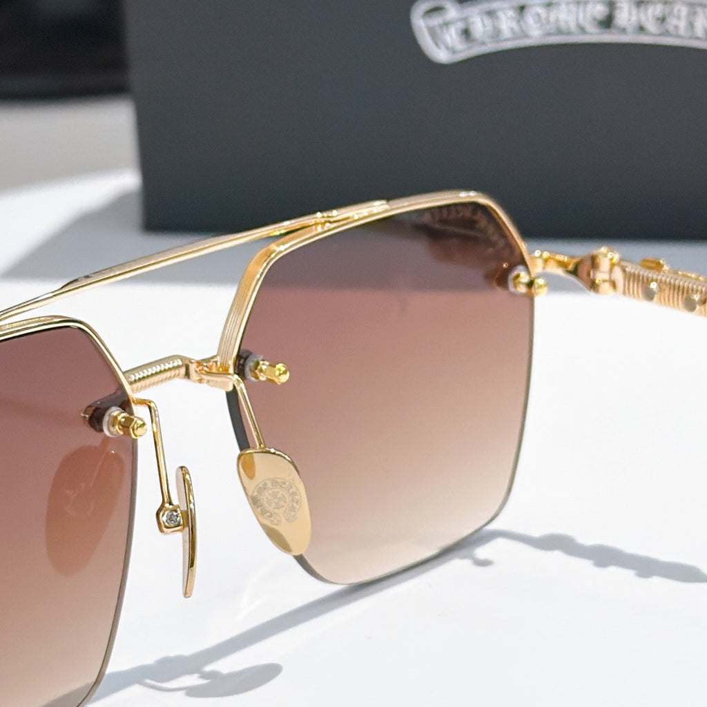 Chrome metal sunglasses close-up of gold lens frame, hinge, and temple details