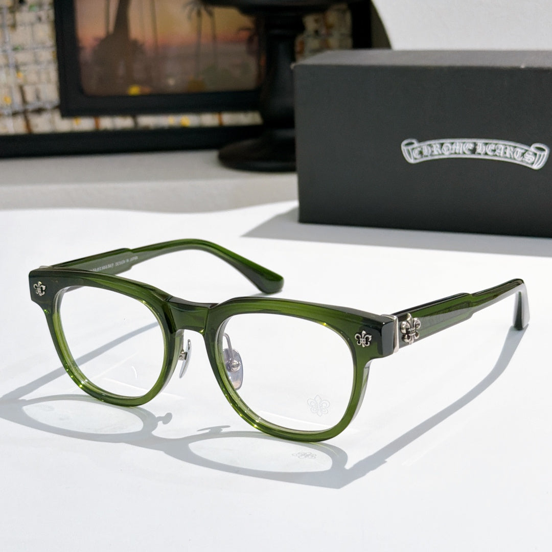 Green eyeglass frames with silver hardware and fleur-de-lis side accents
