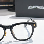 Black eyeglass frame with gold hinge detail and round-rectangle lens
