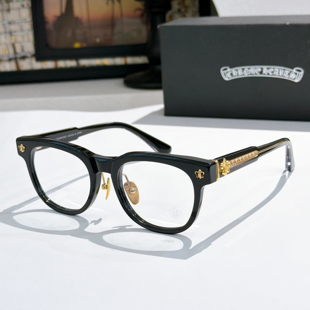 Black eyeglass frames with gold decorative temples and clear lenses