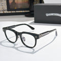 Black eyeglass frames with gold fleur-de-lis details and clear lenses