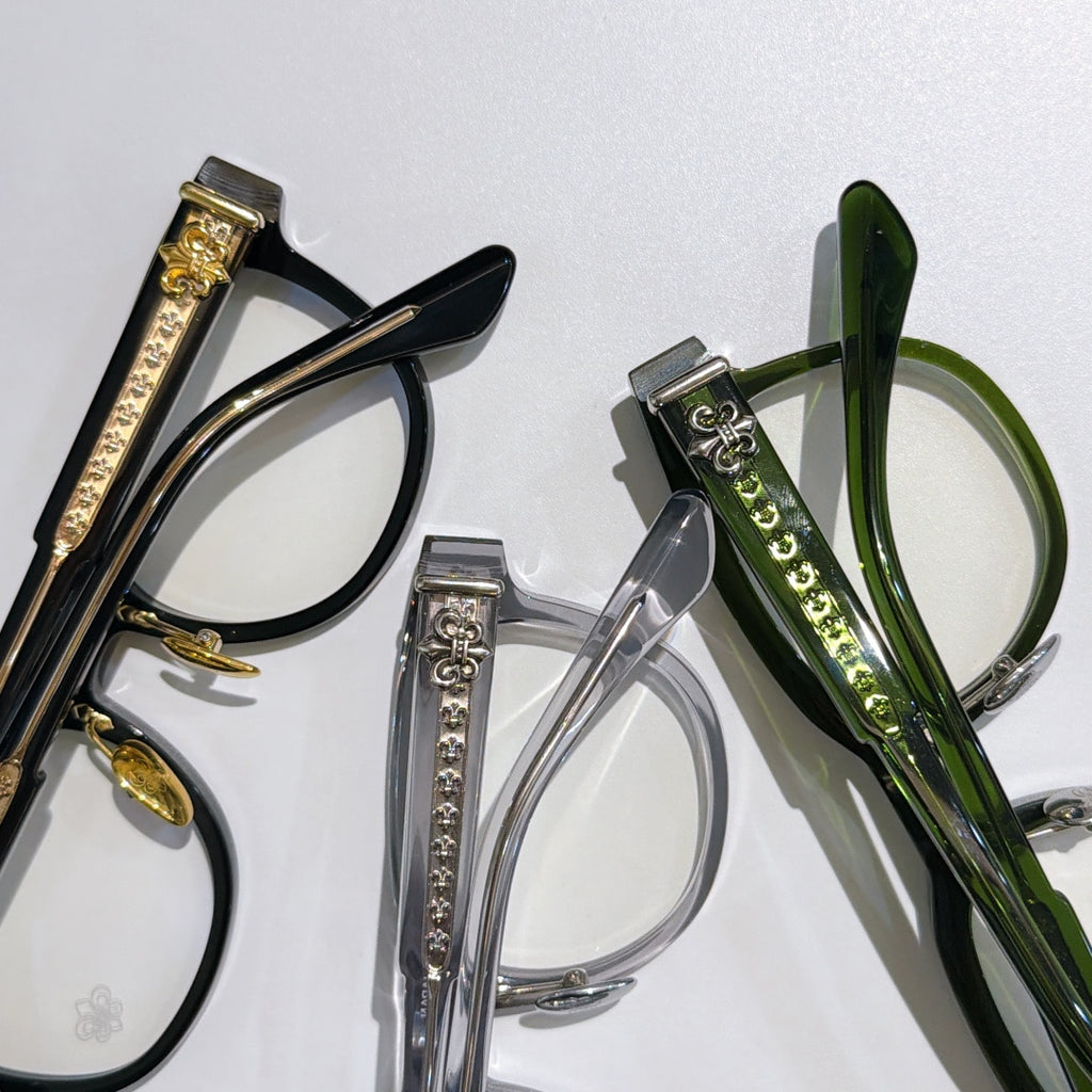 Assorted eyeglass frames with gold hardware, clear and green lenses