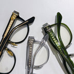 Assorted eyeglass frames with gold hardware, clear and green lenses